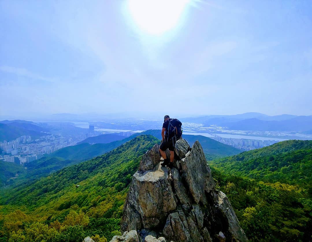 A photo of Bogue reaching the Summit of a mountain in Busan.